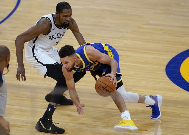 Golden State Warriors guard Stephen Curry, right, is defended by Brooklyn Nets forward Kevin Durant during the first half of an NBA basketball game in San Francisco