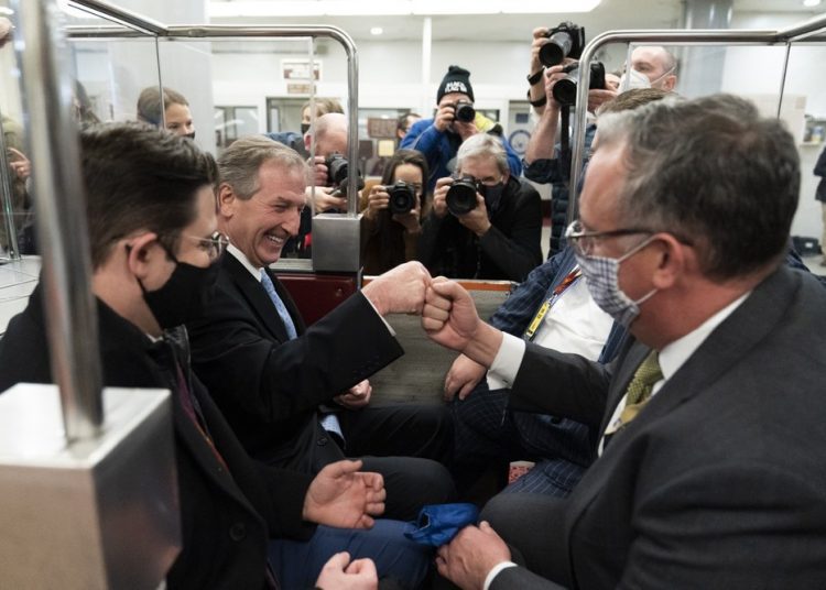 Michael van der Veen, second from left an attorney for former President Donald Trump, fist bumps a colleague as the depart on the Senate Subway, on Capitol Hill after the Senate acquitted Trump in his second impeachment trial in the Senate at the U.S. Capitol in Washington, Saturday, Feb. 13, 2021. Trump was accused of inciting the Jan. 6 attack on the U.S. Capitol, and the acquittal gives him a historic second victory in the court of impeachment