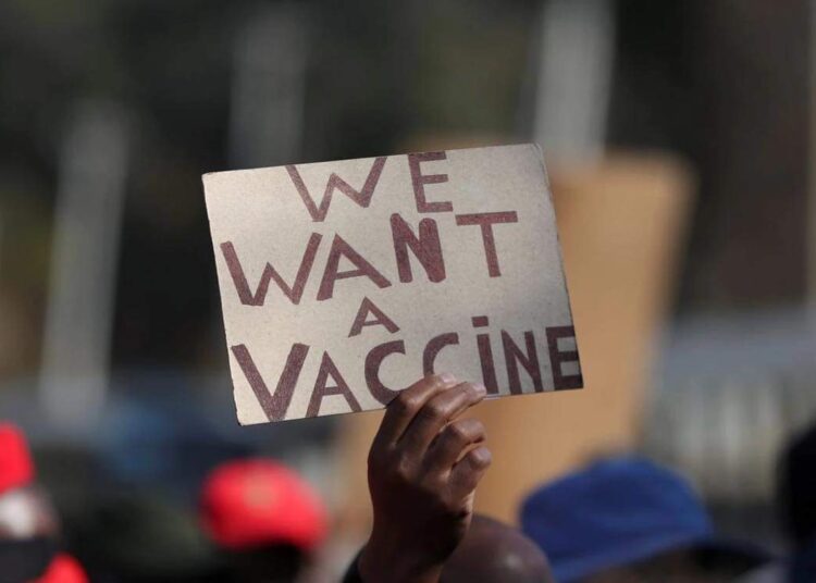 A person holding a placard as supporters of the Economic Freedom Fighters (EFF) march to demand a rollout of coronavirus disease vaccines, in Pretoria, South Africa.