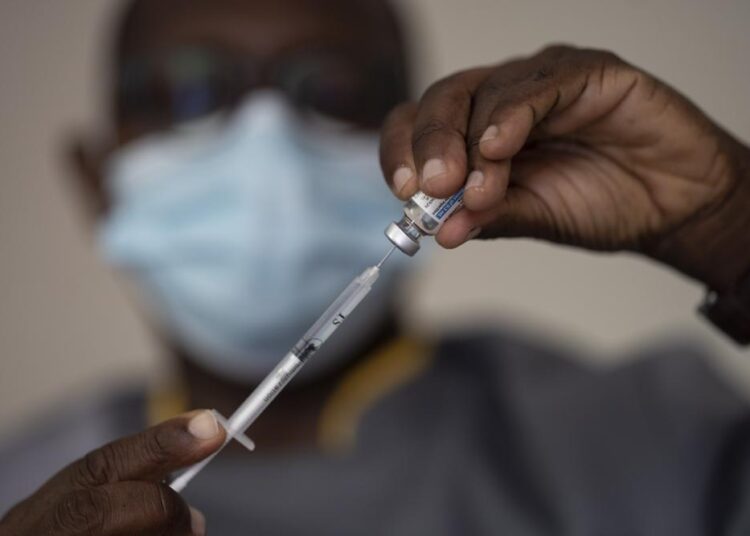 FILE—In this Wednesday, July 28, 2021 file photo, a health worker administers a dose of Janssen COVID-19 vaccine by Johnson & Johnson in the Medina neighborhood in Dakar, Senegal. Thousands of new coronavirus cases have been reported in West Africa in recent weeks amid low vaccination rates and the spread of the delta variant. Officials say cases have risen sharply in Senegal, Ghana, Nigeria and elsewhere.