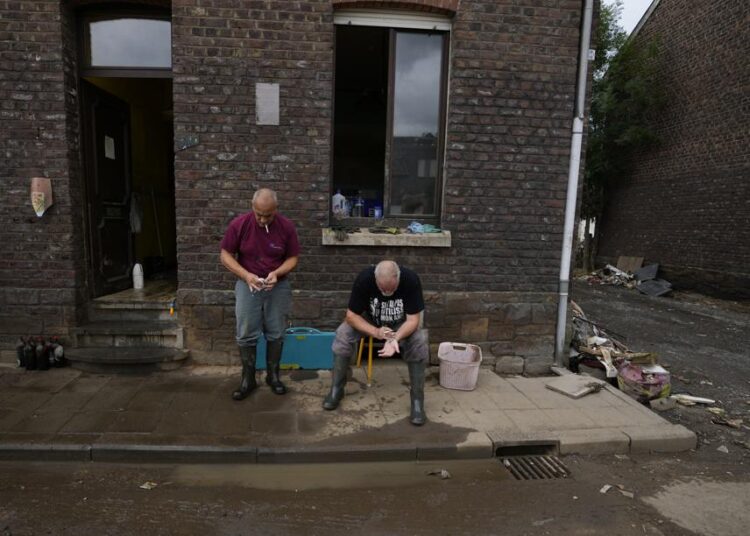 Nightmares, panic attacks: Belgian flood survivors struggle 1 - Egyptian Gazette Resident Patrick Martin, right, and a friend in front of their flood damaged home in the La Brouck neighborhood of Trooz, Belgium, on Tuesday.
