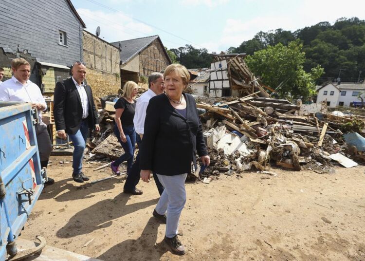 German Chancellor Angela Merkel, center, informs herself in the district of Iversheim about the situation in the flood-affected area and meet victims of the flood disaster.