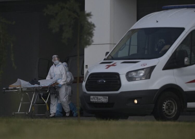 Health workers wearing protective gear push a stretcher outside the hospital complex where patients infected with the Covid-19 are being treated in the settlement of Kommunarka, outside Moscow, on July 16, 2021. (Photo by Natalia KOLESNIKOVA / AFP)