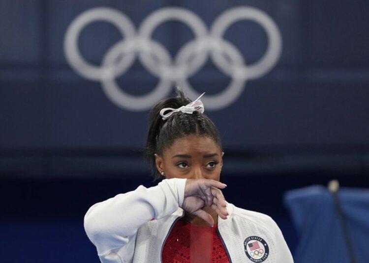 Simone Biles, of the United States, watches gymnasts perform at the 2020 Summer Olympics, on Tuesday, July 27, 2021, in Tokyo.
