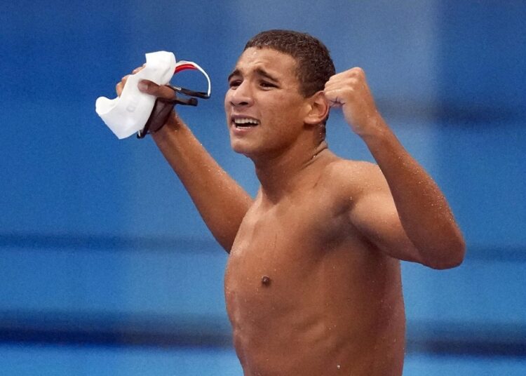Olympics- Swimming: Tunisia’s Hafnaoui wins gold 1 - Egyptian Gazette Ahmed Hafnaoui, of Tunisia, celebrates after winning the final of the men's 400-meter freestyle at the 2020 Summer Olympics, Sunday, July 25, 2021, in Tokyo.