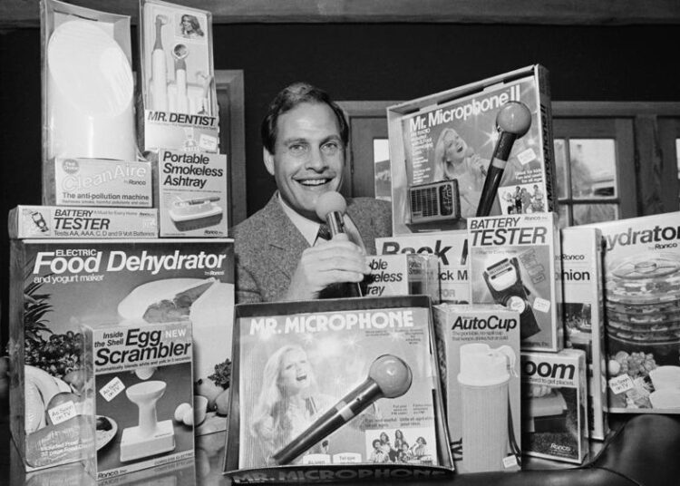 A file photo, Ron Popeil, the man behind those late-night, rapid-fire television commercials that sell everything from the Mr. Microphone to the Pocket Fisherman to the classic Veg-a-Matic, sits surrounded by his wares in his office in Beverly Hills, Calif. Ron Popeil, the quintessential TV pitchman and inventor known to generations of viewers for hawking products including the Veg-O-Matic, the Chop-O-Matic, Mr. Microphone and the Showtime Rotisserie and BBQ, died on Wednesday.
