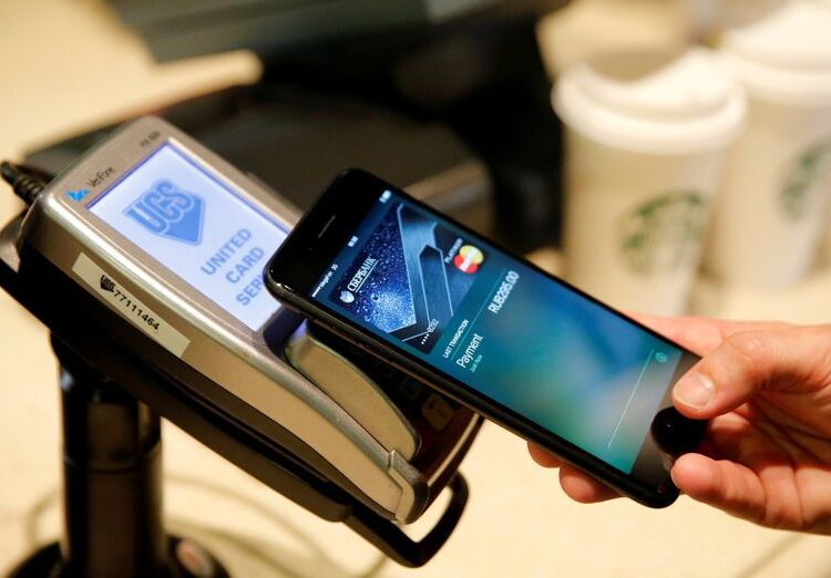 A man uses an iPhone 7 smartphone to demonstrate the mobile payment service Apple Pay at a cafe in Moscow. (File Photo)