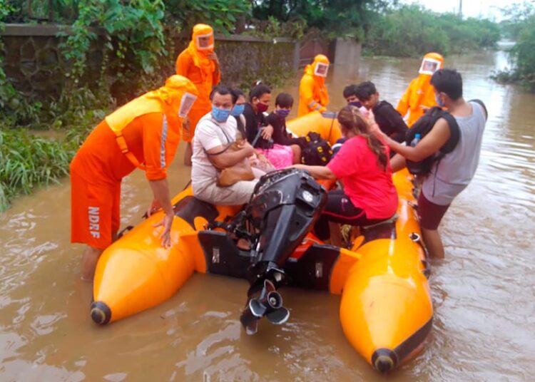 Landslides in western India kill 32, while floods trap more 1 - Egyptian Gazette This photograph provided by India's National Disaster Response Force (NDRF) shows NDRF personnel rescuing people stranded in floodwaters in Bhiwandi, in the western Indian state of Maharashtra, Thursday, July 22, 2021.
