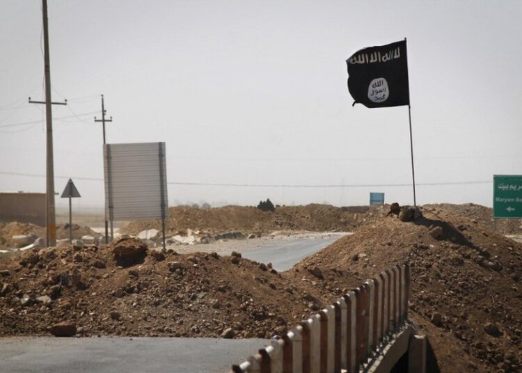 (FILES) - A file picture taken on September 11, 2014, shows a flag of the Islamic State (IS) group on the other side of a bridge at the frontline of fighting between Kurdish Peshmerga fighters and Islamist militants in Rashad, on the road between Kirkuk and Tikrit. Three Iraqi policemen were killed on September 30, 2014 when one of them tried to remove a black flag that Islamic State jihadist fighters had booby-trapped south of Kirkuk, police said.   AFP PHOTO/JM LOPEZ