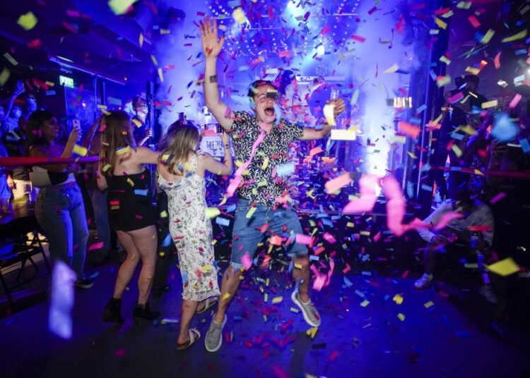 Virus surge fears, UK leader’s quarantine, mar ‘Freedom Day’ 1 - Egyptian Gazette A man jumps on the dance floor shortly after the reopening, at The Piano Works in Farringdon, in London, Monday.