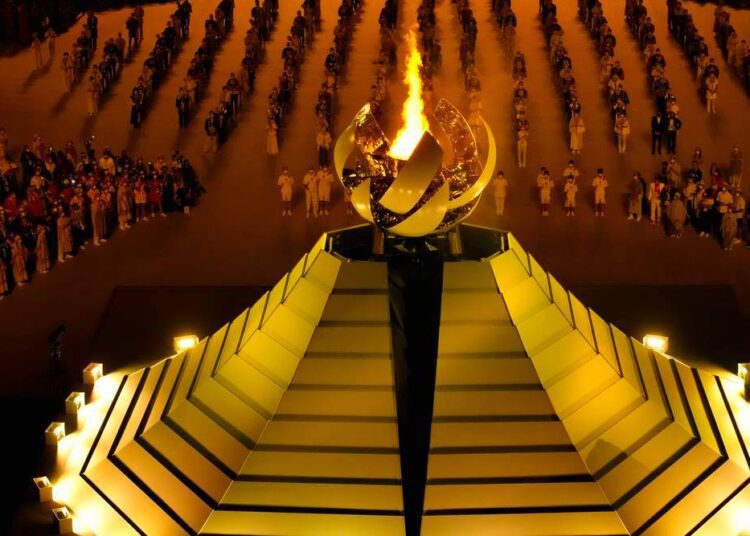 The Olympic flame burns during the opening ceremony in the Olympic Stadium at the 2020 Summer Olympics.