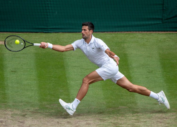 Djokovic into 10th Wimbledon semi-final, 41st at Slams 1 - Egyptian Gazette Serbia's Novak Djokovic returns against Hungary's Marton Fucsovics during their men's quarter-finals match on the ninth day of the 2021 Wimbledon Championships at The All England Tennis Club in Wimbledon, southwest London, on July 7, 2021. (Photo by AELTC/Florian Eisele / POOL / AFP) / RESTRICTED TO EDITORIAL USE