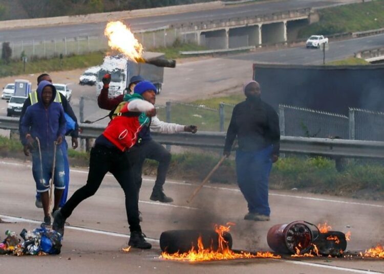 S. African police arrest 27 over protests linked to Zuma jailing 1 - Egyptian Gazette Supporters of Jacob Zuma block the freeway with burning tyres during a protest in Peacevale, South Africa, July 9, 2021.