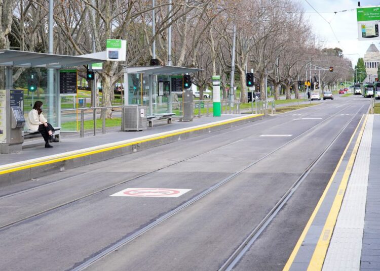 A lone passenger sits at a tram stop on a mostly-empty city centre street on the first day of a lockdown as the state of Victoria looks to curb the spread of a coronavirus disease (COVID-19) outbreak in Melbourne, Australia, yesterday.