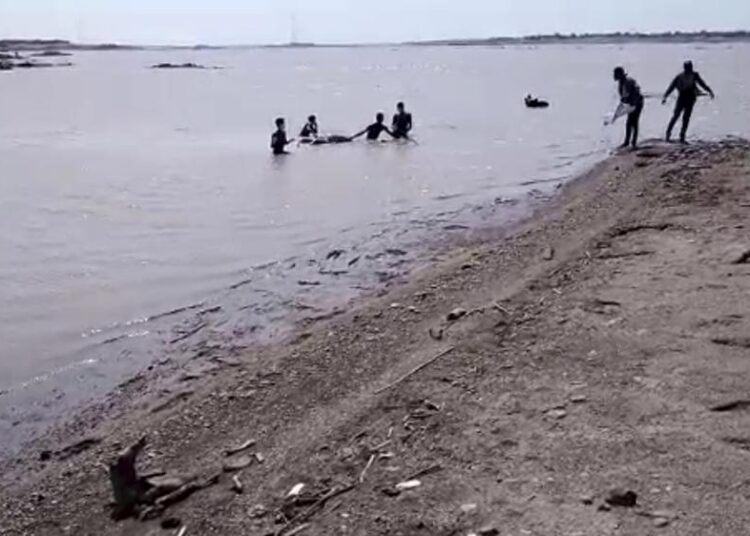 In this image from video obtained by The Associated Press, refugees from Ethiopia recover a body found in the Setit River, known in Ethiopia as Tekeze River, at Wad el Hilu, Sudan, on Wednesday, Aug. 4, 2021.