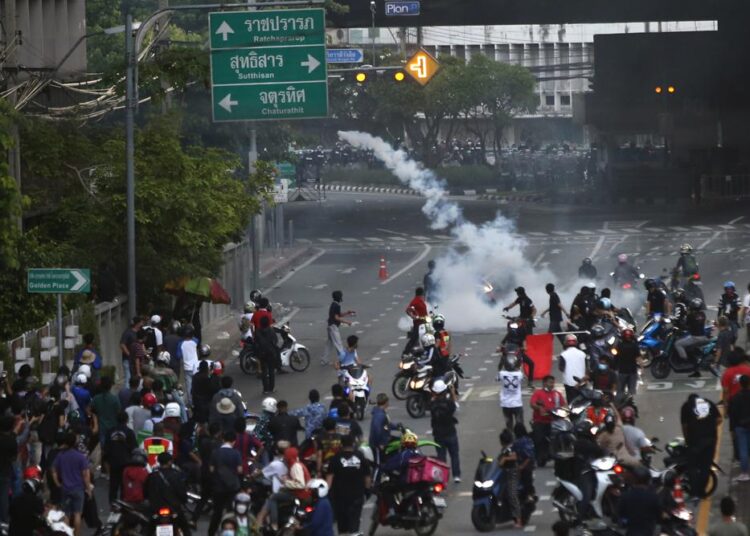 Riot police launch tear gas to anti-government protesters during a protest in Bangkok, Thailand, Saturday, Aug. 7, 2021.