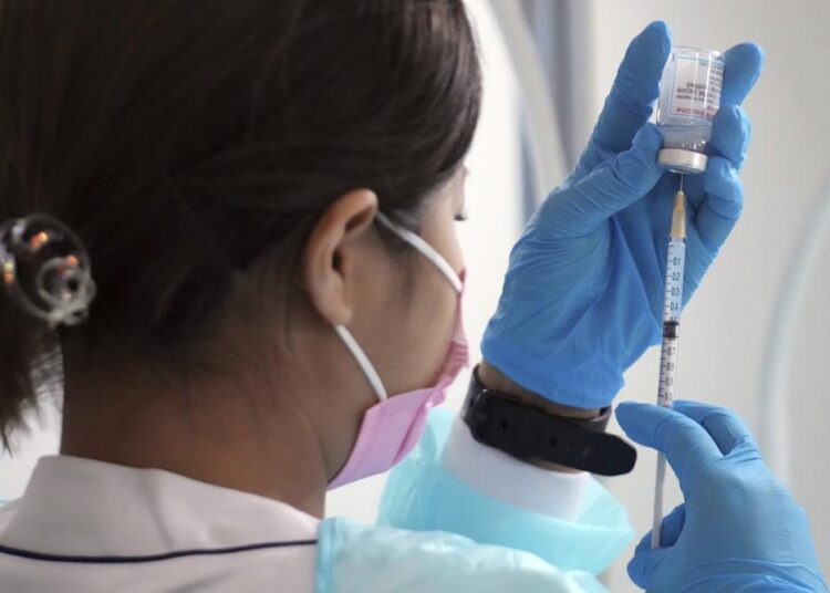 Japan suspends 1.63m doses of Moderna over contamination 1 - Egyptian Gazette A file photo of a health worker preparing a dose of the Moderna Covid-19 vaccine at Sumida ward of Tokyo.