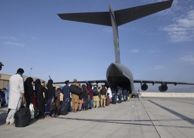 In this image provided by the U.S. Air Force, U.S. Air Force loadmasters and pilots assigned to the 816th Expeditionary Airlift Squadron, load people being evacuated from Afghanistan onto a U.S. Air Force C-17 Globemaster III at Hamid Karzai International Airport in Kabul, Afghanistan, Tuesday, Aug. 24, 2021.