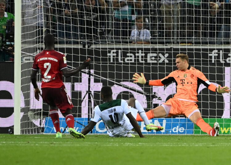Bayern Munich goalkeeper Manuel Neuer blocks an attempt on goal from Moenchengladbach Marcus Thuram during their German Bundesliga match on August 13, 2021.