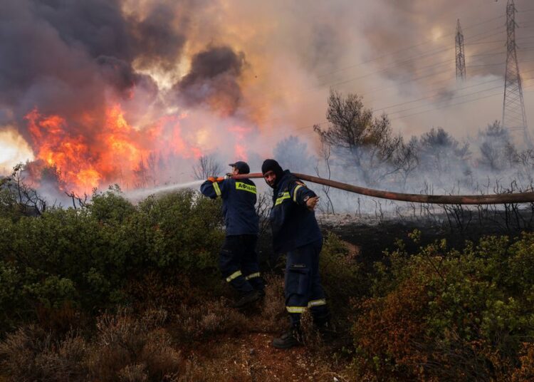 Firefighters operate after a wildfire in Thrakomacedones area, in northern Athens, Greece, Sunday, Aug. 8, 2021.