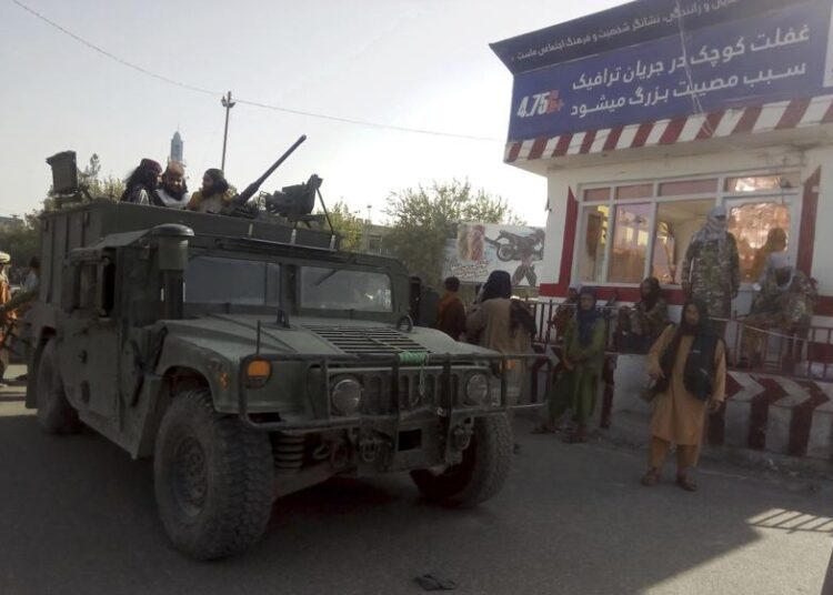 Taliban fighters standing guard at a checkpoint in Kunduz city, northern Afghanistan, Monday, Aug. 9, 2021. The militants have ramped up their push across much of Afghanistan in recent weeks, turning their guns on provincial capitals after taking district after district and large swaths of land in the mostly rural countryside.