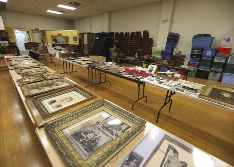 In this Jan. 12, 2021 photo, tables are filled with prints of all sizes that were found in an attic and brought to the antique and auction shop in Canandaigua, N.Y. A rare framed photograph of Susan B. Anthony is being auctioned with a starting price of $5,000. The 20-by-16-inch photo was found in an concealed attic space in a building in Geneva, N.Y, after the property was sold in December. The owner of the building, David Whitcomb, has worked with an antiques dealer to bring some 350 items discovered in the attic to auction.