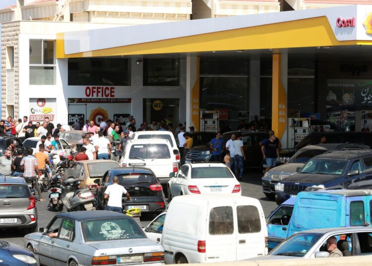 Motorbike and car drivers wait to get fuel at a gas station, after the central bank decided to effectively end subsidies on fuel imports, in Damour, Lebanon, August 13, 2021.