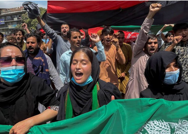 People carry the national flag at a protest held during the Afghan Independence Day in Kabul, Afghanistan August 19, 2021