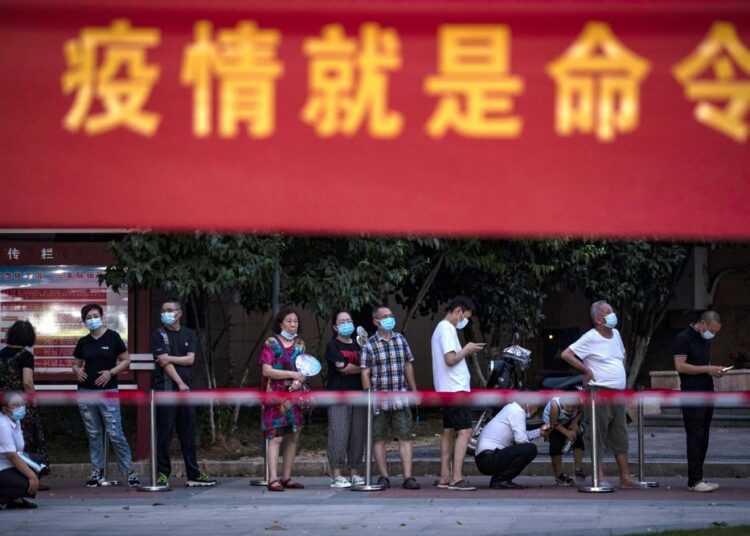 Residents line up for Covid-19 tests near a banner with the words "Epidemic is the Order" in Wuhan in central China's Hubei province on Tuesday.