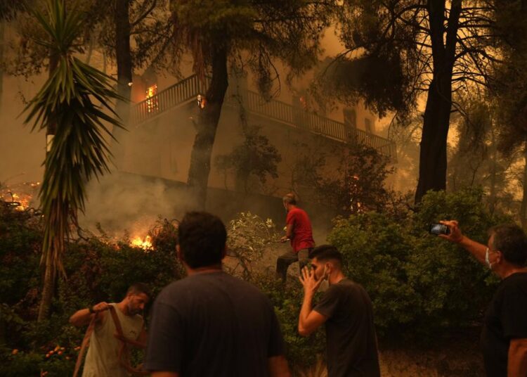 Flames burn a house at Pefki village on Evia island, about 189 kilometers (118 miles) north of Athens, Greece, on Sunday.