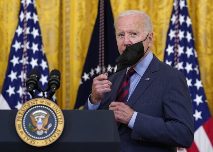 President Joe Biden takes off his mask as he arrives to speak about the coronavirus pandemic in the East Room of the White House in Washington, on Aug. 3, 2021.