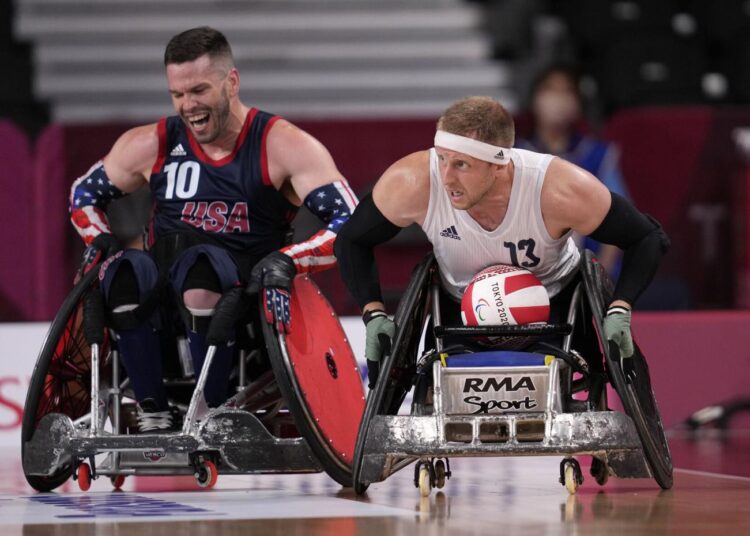 Britain's Aaron Phipps (R) moves the ball against Joshua Wheeler of the United States during the wheelchair rugby gold medal match at the Tokyo 2020 Paralympic Games, Sunday, Aug. 29, 2021, in Tokyo.