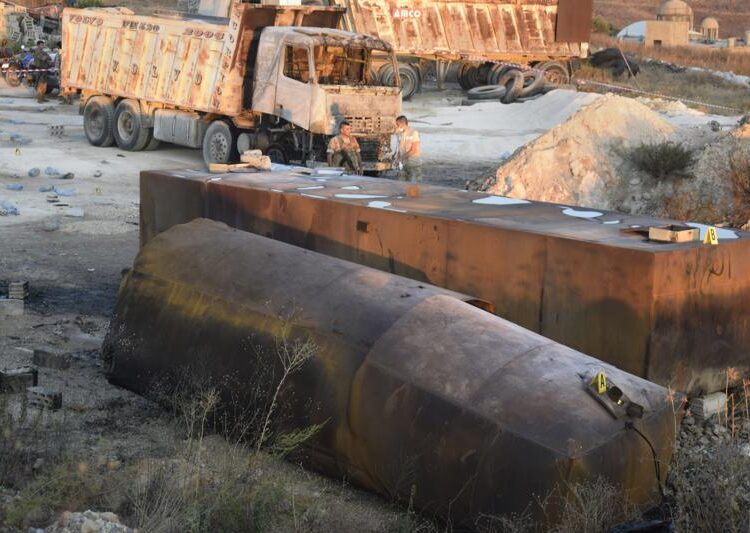 Lebanese soldiers stand guard next to fuel tankers that were exploded, in Tleil village, north Lebanon, Sunday, Aug. 15, 2021. A warehouse where fuel was illegally stored exploded early Sunday in northern Lebanon, killing and wounded several people, the Lebanese Red Cross said. The explosion comes as Lebanon faces a severe fuel shortage that has been blamed on smuggling, hoarding and the cash-strapped government's inability to secure deliveries of imported fuel.
