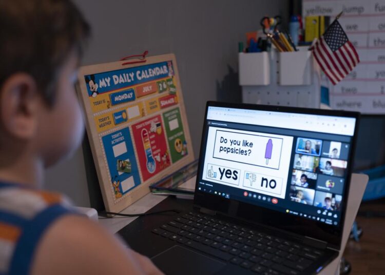 Logan Strauss participates in an online class from home in Basking Ridge, N.J., on July 28, 2021. Logan's parents are keeping him out of school until he gets the COVID-19 vaccine.