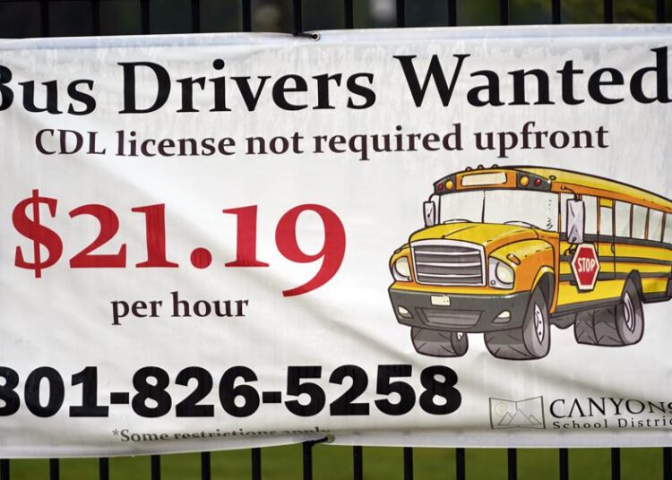 A "Bus Drivers Wanted" sign is shown on Aug. 18, 2021, in Sandy, Utah. A shortage of bus drivers is complicating the start of a new school year already facing a surge in COVID-19 cases and conflicts over whether masks should be required in school buildings.
