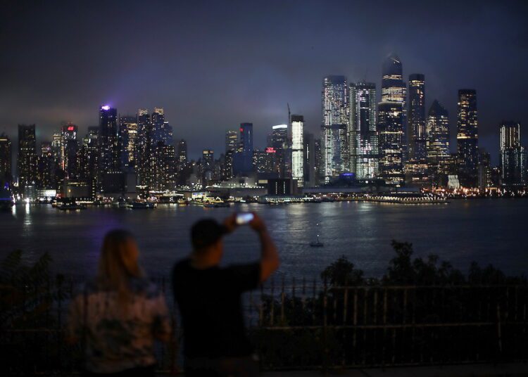 People watch clouds pass over middle Manhattan as Tropical Storm Henri passes through New York City.