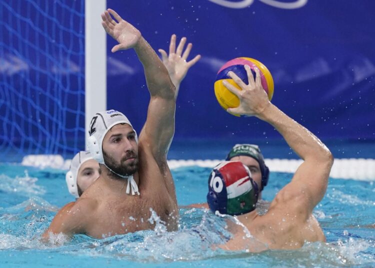 Greece's Angelos Vlachopoulos (L) defends against Hungary's Denes Varga (R) during a semi-final round men's water polo match at the 2020 Olympics, Friday, Aug. 6, 2021, in Tokyo.