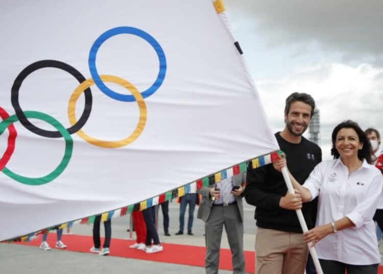 Mayor of Paris Anne Hidalgo (R) poses as she holds the Olympic flag with President of the Paris 2024 Organising Committee Tony Estanguet on August 9, 2021.