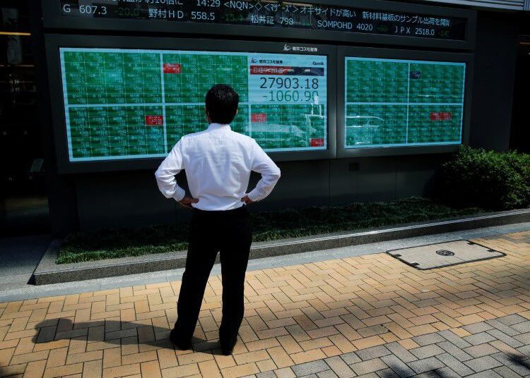 Stocks mixed amid concerns over Delta variant, tapering talk 1 - Egyptian Gazette A man watches an electric board showing Nikkei index outside a brokerage at a business district in Tokyo, Japan, June 21, 2021.
