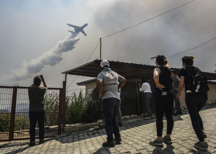 A plane pours water over the fire-devastating Sirtkoy village, near Manavgat, Antalya, Turkey, on Sunday.