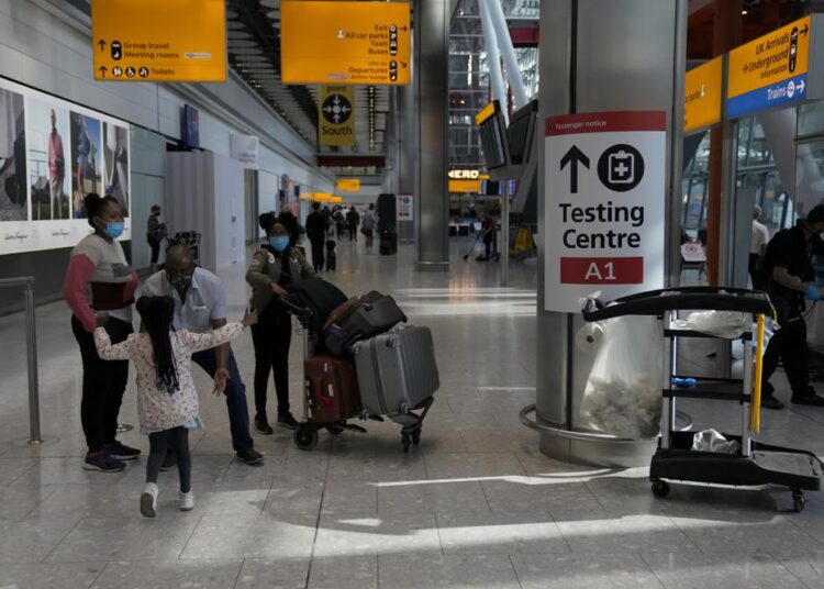 UK eases travel restrictions as industry lobbies for more 1 - Egyptian Gazette Passengers are greeted by a child as they arrive at Terminal 5 of Heathrow Airport in London, on Monday.