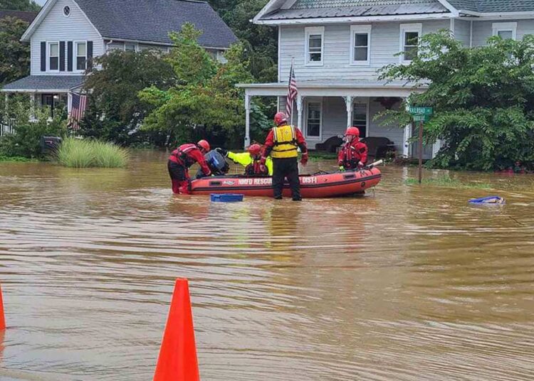 In this photo provided by Mayor Chris Slavicek, emergency personnel and first responders work to help residents after heavy rains from Henri flooded the area, on Aug. 22, 2021, in Helmetta, N.J.
