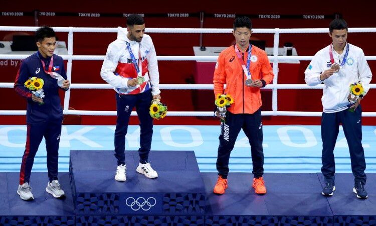 Gold medallist Galal Yafai of Britain, Silver medallist Carlo Paalam of the Philippines, Bronze medallists Ryomei Tanaka of Japan and Saken Bibossinov of Kazakhstan stand on the podium during the medal ceremony.
