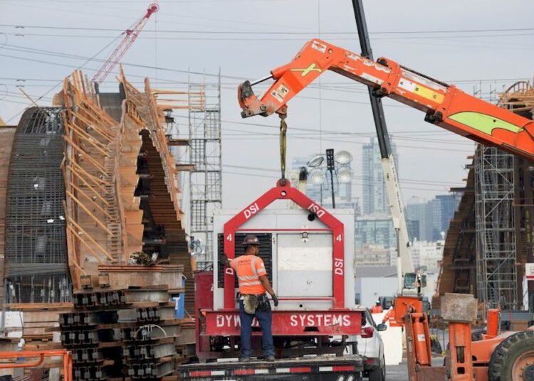 A Skanska contractor guides heavy machinery during the construction works of the Sixth Street Viaduct replacement project in Downtown Los Angeles, California, US, August 11, 2021.