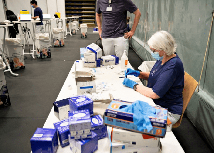 A medical worker handles syringes as Danes get vaccinated against the coronavirus disease (COVID-19) while the Aalborg Symphony Orchestra plays at the vaccination site in Arena Nord in Frederikshavn, Jutland, Denmark April 12, 2021.