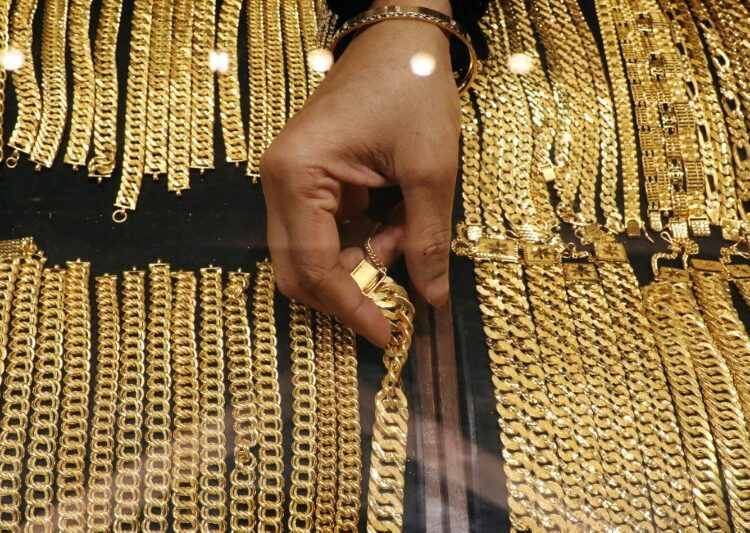 A vendor arranges gold chains displayed at VJ Gold and Diamond jewellery shop in Kuala Lumpur, Malaysia.