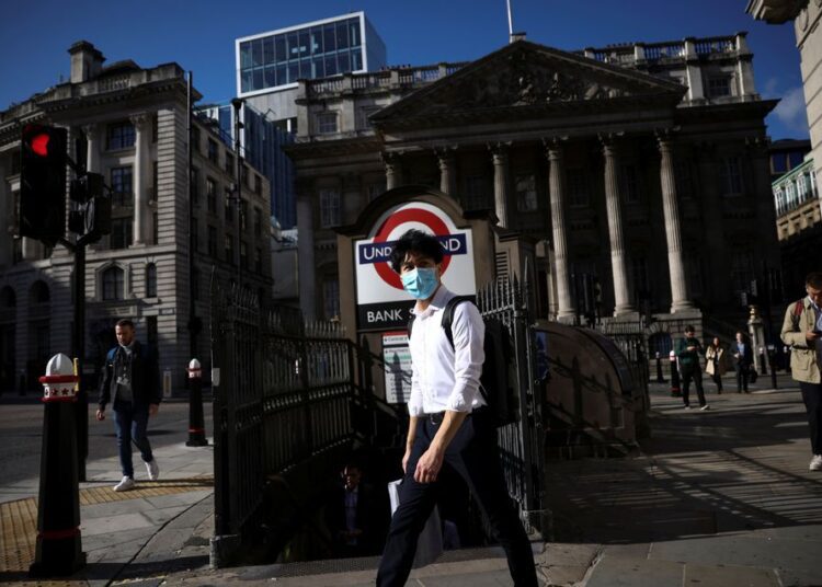 A person walks past Bank underground station during morning rush hour, amid the coronavirus disease (COVID-19) pandemic in London.