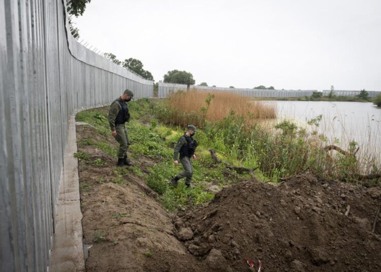 FILE - In this May 21, 2021, file photo, policemen patrol alongside a steel wall at Evros river, near the village of Poros, at the Greek -Turkish border, Greece. Haunted by a 2015 migration crisis fueled by the Syrian war, European leaders desperately want to avoid another large-scale influx of migrants and refugees from Afghanistan.