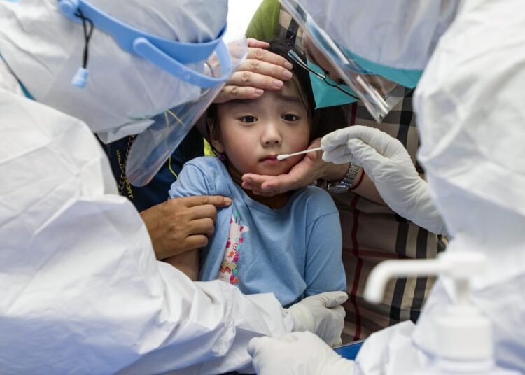 Delta variant challenges China’s costly lockdown strategy 1 - Egyptian Gazette A child reacts to a throat swab during mass testing for COVID-19 in Wuhan in central China's Hubei province Tuesday, Aug. 3, 2021. The coronavirus’s delta variant is challenging China’s costly strategy of isolating cities, prompting warnings that Chinese leaders who were confident they could keep the virus out of the country need a less disruptive approach.