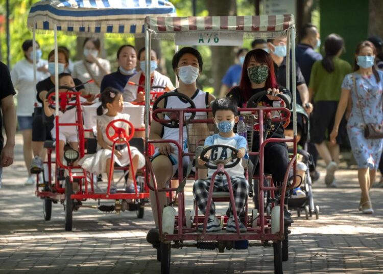 China allows couples third child amid demographic crisis 1 - Egyptian Gazette Adults and children ride pedal cycles at a public park in Beijing, Saturday, Aug. 21, 2021. China will now allow couples to have a third child as the country seeks to hold off a demographic crisis that threatens its hopes of increased prosperity and global influence.